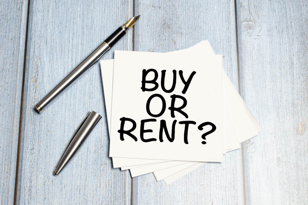 acheter ou louer écrit sur une feuille de papier à côté d'un stylo sur une table en bois