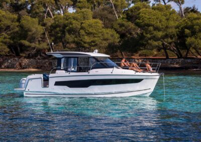 Bateau Merry Fisher 895 naviguant sur une eau turquoise avec des passagers à bord
