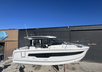 Bateau Merry Fisher 895 vu de profil à quai devant un bâtiment nautique