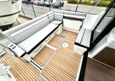Cockpit arrière du Merry Fisher 895 avec banquette en U et plancher en teck