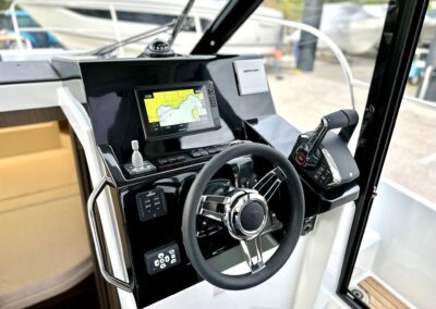 Poste de pilotage du Merry Fisher 895 avec volant et écran GPS