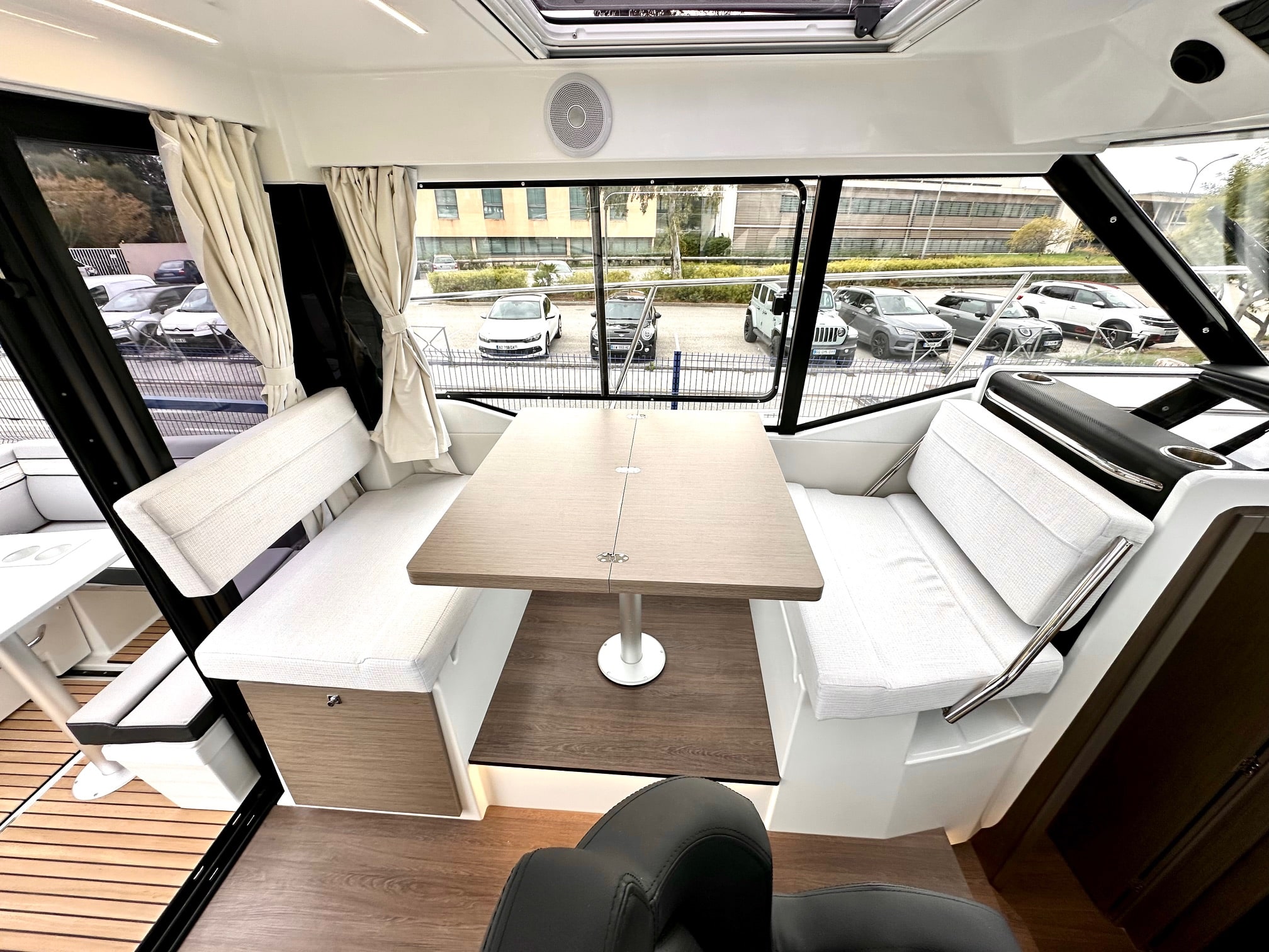 Salon intérieur du Merry Fisher 895 avec banquettes face à face et table centrale