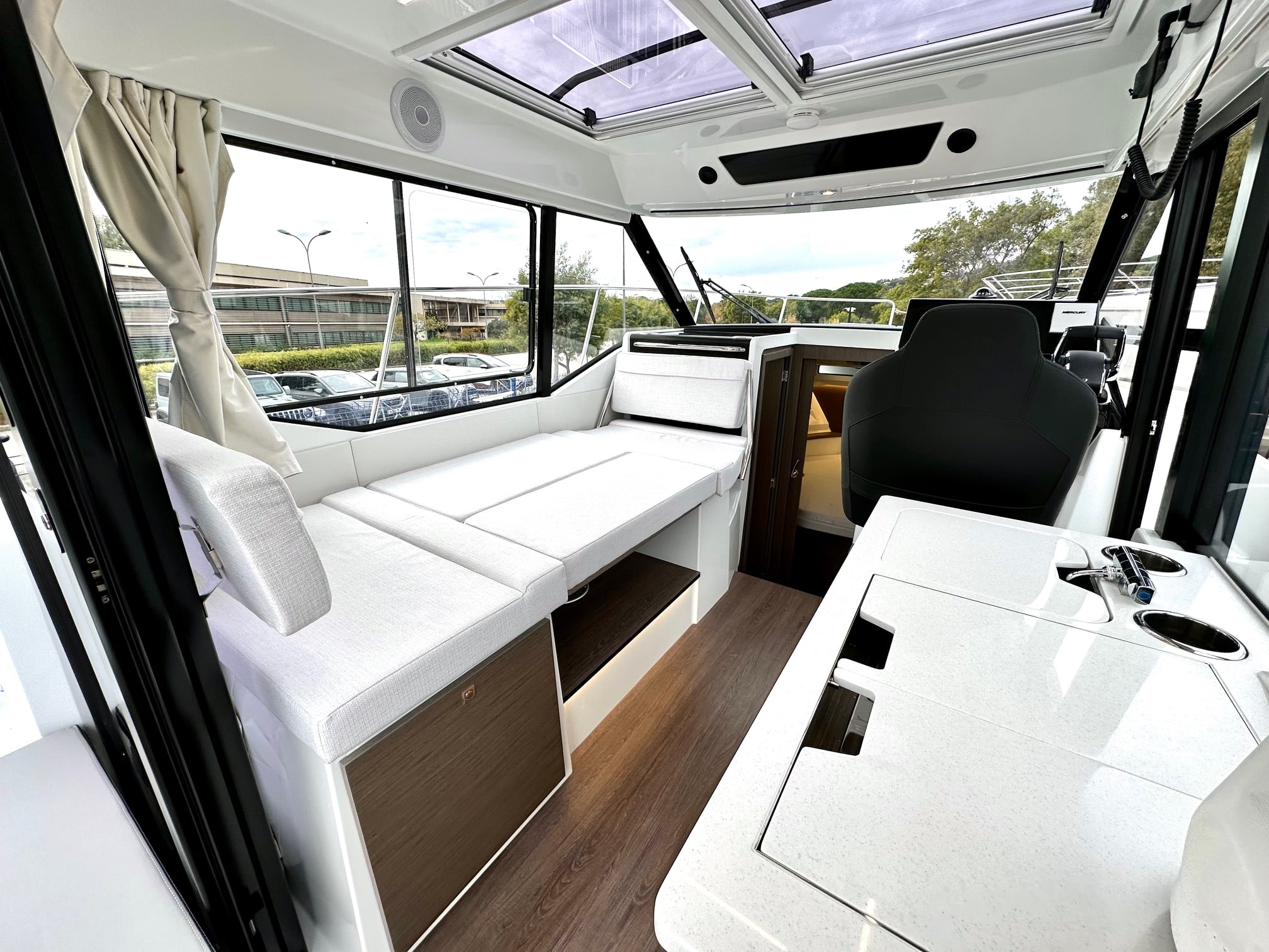Salon intérieur du Merry Fisher 895 avec banquette et cuisine équipée