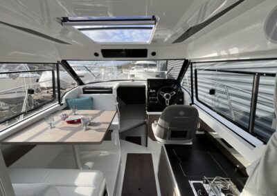 Vue intérieure du Merry Fisher 795 Série 2 avec poste de pilotage et coin repas
