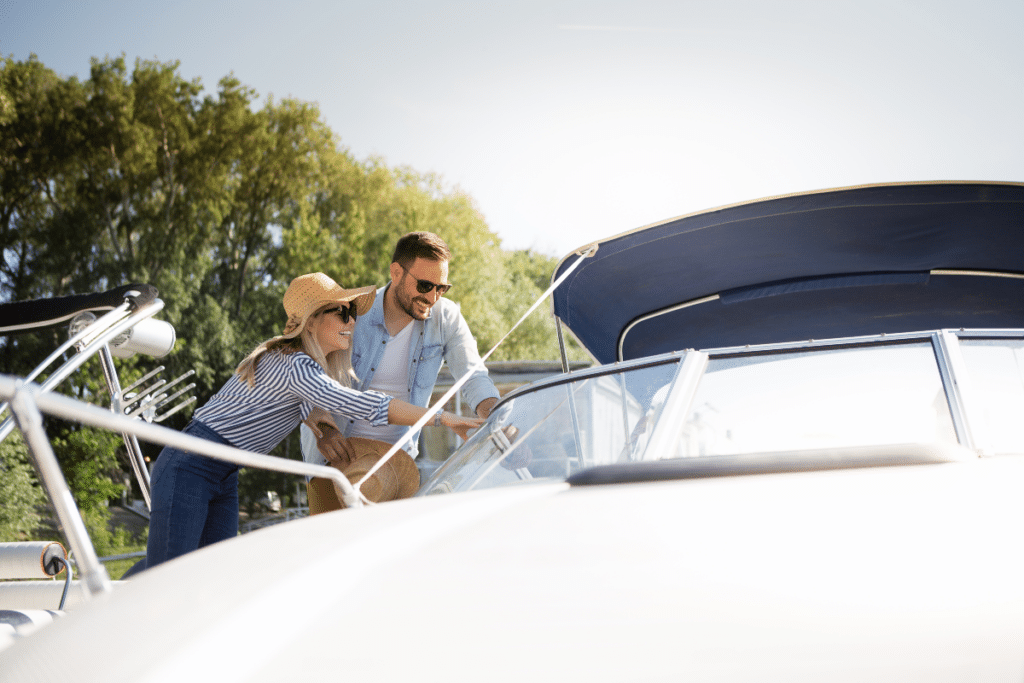 Un jeune couple regarde un bateau à moteur qu'ils ont l'intention d'acheter.